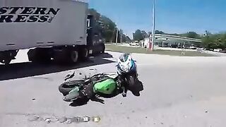 Biker slides under a turning truck