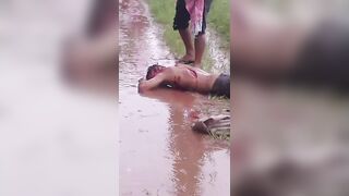 Mangled Man Convulses in Agonizing Pain, Covered in Machete Wounds and Filthy Mud