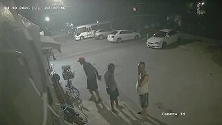 Hooded Hitman Ambush: Multiple Shots End Conversation on the Sidewalk