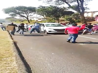 South African looters, smash up a car.
