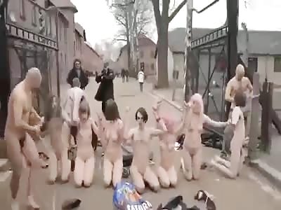 Security struggle with naked protesters outside the gates of Auschwitz.