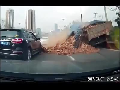 Car buried by truckload of Bricks