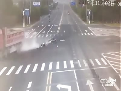 Woman riding a scooter runs a red light and gets destroyed by a dump truck 