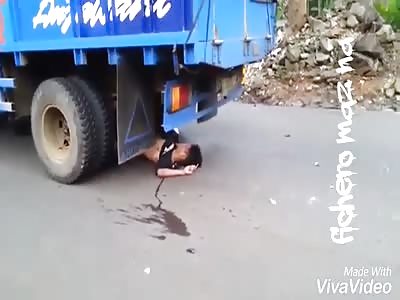 Dead motorcyclist under truck