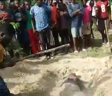 Rapist dead body laying in shallow grave still receives beating 