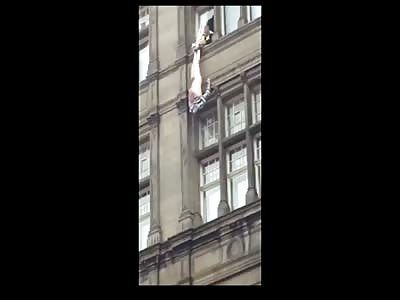 Naked Man Hanging Upside Down from Window Commits Suicide While Police Trying to Rescue Him
