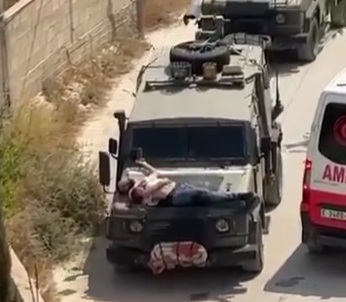 Israeli army injured young Palestinian then tied him to hood of jeep as a human shield 