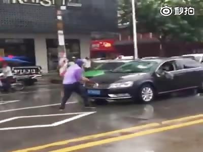 Angry biker attacks the car that rammed him  