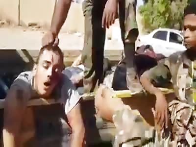 Haftar militia showing their dead enemy 