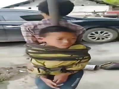 Two young boys tied to pole as a punishment for refusing working 