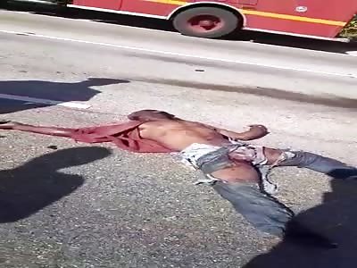 Corpse of a man killed in brutal accident lying on the street.
