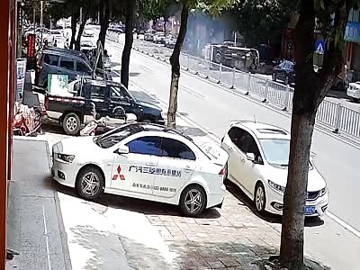 Chinese motorcyclist nearly crushed under ambulance 