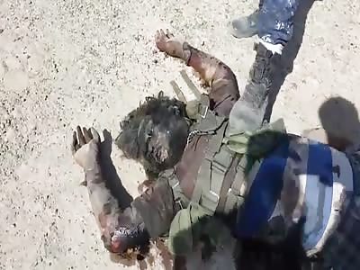 Iraqi soldiers show their fallen opponent