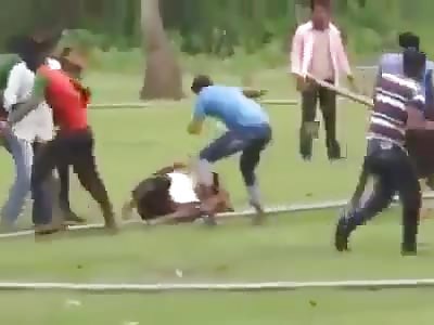 man brutally beating with piece of wood