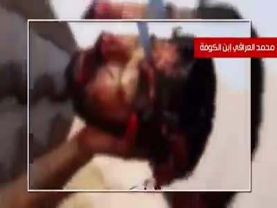 Iraqi soldier shows like a triumph a knife nailed to the decapitated head