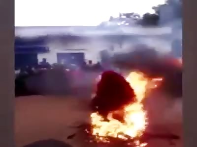 African witch sits/stands in fire