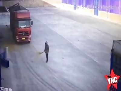 a man sweeping the road is crushed by a very slow truck going in reverse in Guangdong