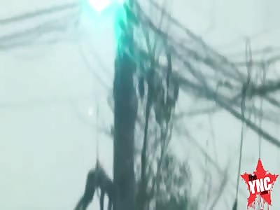 a man hanging of a electricity utility pole while its exploding in Guiyang City