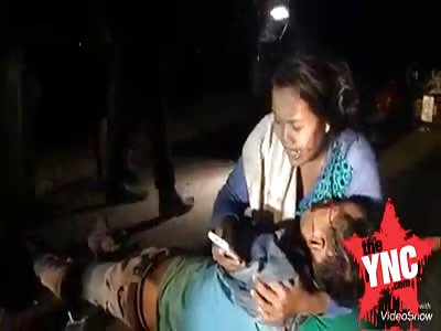 woman holds the arms of her dead husband in Cambodia 