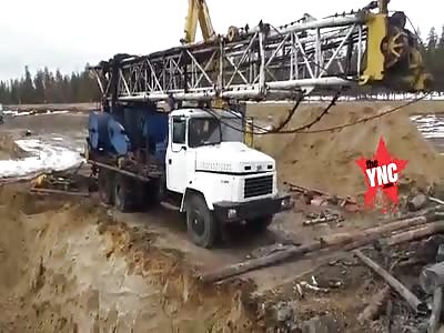 bankrupt Russian man takes his anger out in his backhoe with a man still inside the crane 