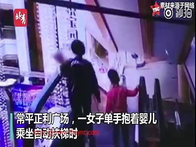 a baby dies after her mother dropped it by accident while on the escalator in Guangdong.