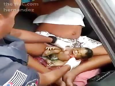 Woman giving birth by car