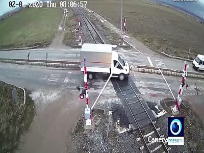 A mini van gets hit by a train on the crossing. 2 angles.