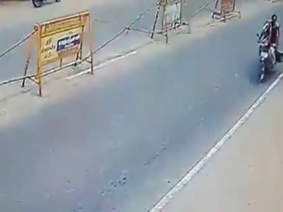 Indian motorcyclist falls under a truck and is killed.