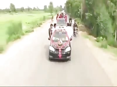 Two guys fly high at Indian wedding procession.