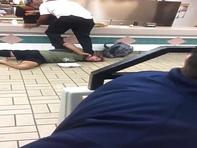 Man is knocked to the ground and tasered for giving racist abuse to staff in Burger King.