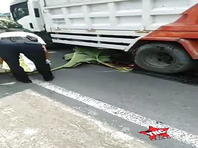 Body crushed by truck and smeared on the road.