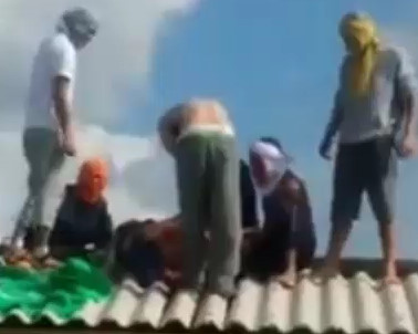 Prison guard being decapitated on the roof by inmates