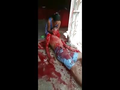Woman in Despair Holds Her Dying Husband in Her Lap as Blood Spews out of His Mouth