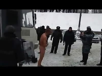 Video of Riot Police stripping detained protester naked in the snow at tempatures below 0 while taking pictures of him