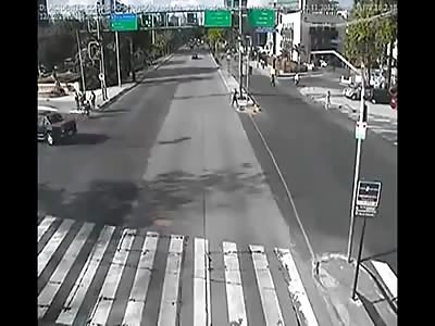 Security camera catches in traffic car running over two bikes crossing 