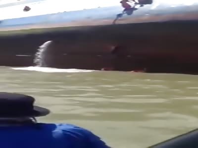 SCARED PASSENGERS CLING TO THE SIDE OF CAPSIZED FERRY