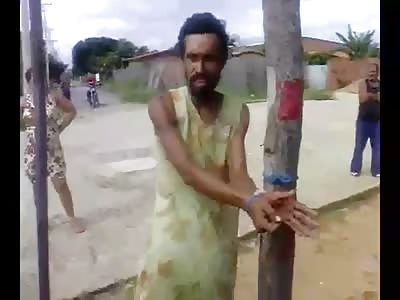 Transvestite tied to pole and beaten