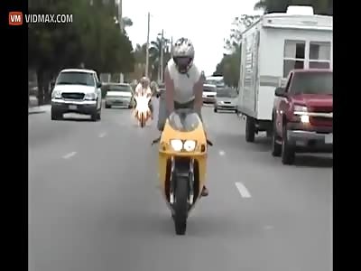 Guy attempts to stand on his motorcycle while driving, ends up destroying the bike and himself